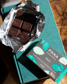 An assortment of handmade and hand-wrapped organic chocolate bar from Pana Organic, perfect for on-the-go snacking or indulging in mixed flavors.
